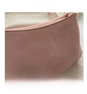 Gros plan des coutures fines et texture en daim doux du sac à main rose clair