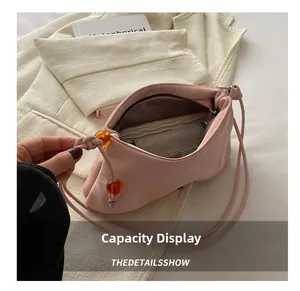 Détail du sac hobo rose à grande capacité avec des perles décoratives en résine orange