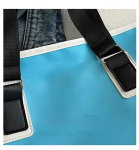 Detail of light blue tote bag with durable oxford fabric and black woven shoulder strap
