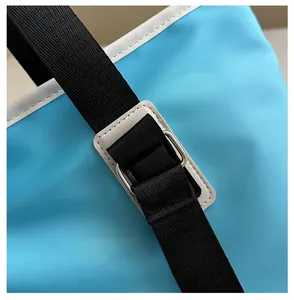Detailed close-up of bright blue fabric texture with black woven strap and metal buckle