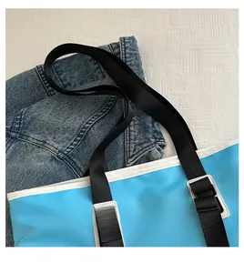 Close-up of blue travel tote bag handle and comfortable white piping detail