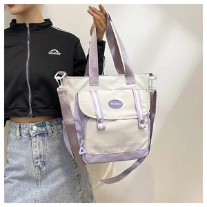 Detail of color-block canvas tote bag with functional flap pocket and adjustable strap