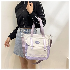 Detailed shot of large capacity canvas bucket tote bag with adjustable shoulder strap on model