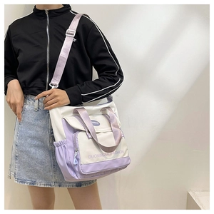 Detail of canvas tote bag with contrast stitching, pockets, and adjustable shoulder strap