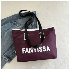 Detail of purple waterproof nylon tote bag with white FANYISSA text and black shoulder strap