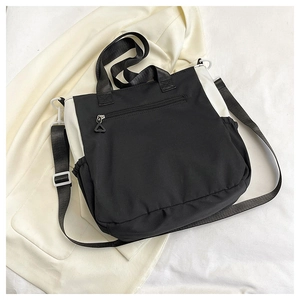 Close-up of contrast black and white tote bag with adjustable strap and side pockets