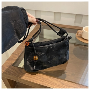 Détails d'un sac à bandoulière vintage en cuir noir souple avec perles d'ambre décoratives