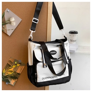 Detail of black and white canvas tote bag with adjustable strap and elastic side pocket