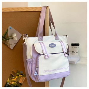 Detail view of large lavender and white canvas crossbody bag with multiple pockets