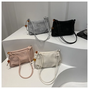 Détail de quatre sacs nuages en rose, blanc, gris et noir avec des perles d'ambre