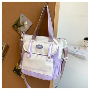 Detail of canvas tote bag showing purple flap pocket and adjustable shoulder strap