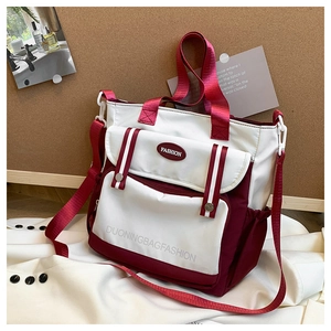 Close-up of color-block tote bag with adjustable shoulder strap and fashion logo
