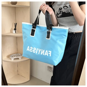 Detail of a bright blue large-capacity Oxford tote bag with stylish white lettering