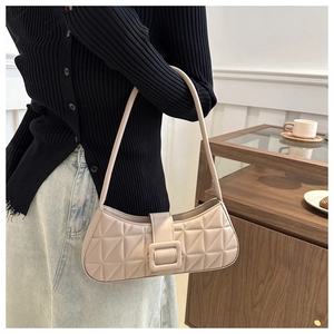 Dettaglio borsa baguette beige trapuntata con motivo a rombi e fibbia quadrata rifinita