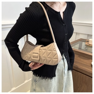 Détail du sac baguette matelassé beige avec motifs géométriques et boucle carrée élégante