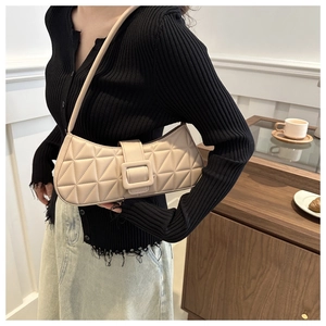 Sac sous le bras beige matelassé avec boucle carrée dans un cadre de vie élégant