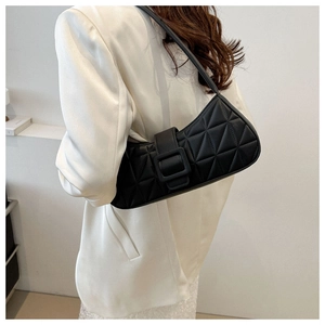 Détail d'un sac baguette noir matelassé avec boucle carrée sur un mannequin