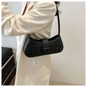 Détail du sac sous le bras noir avec motif à losanges et boucle carrée sur le rabat
