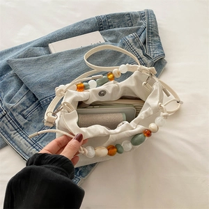White faux leather bucket bag with colorful beaded handle and shoulder strap