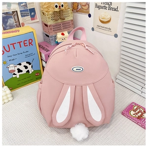 Detail of pink backpack featuring cute rabbit ears and a fluffy white pom-pom tail