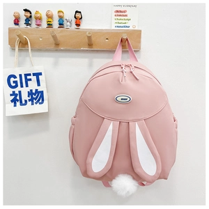 Detail of pink student backpack with plush rabbit ears and sport logo on white wall