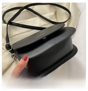 Vue détaillée du fond arrondi et de la structure latérale de ce petit sac bandoulière noir