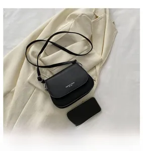 Détail du sac besace noir sur un blazer avec smartphone pour référence de taille