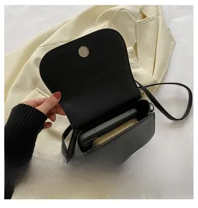 Gros plan sur la capacité de stockage intérieure d'un sac bandoulière selle en similicuir