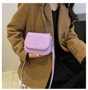 Detail of light purple saddle bag with Fashion Trend print worn on khaki coat