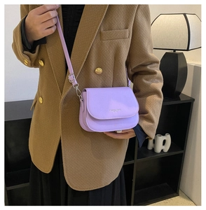 Détail du sac bandoulière en cuir violet clair avec logo et bandoulière réglable