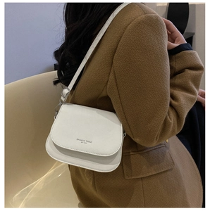 Détail du sac selle en cuir PU blanc avec logo fashion et boucles métalliques