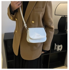 Gros plan d'un sac besace en cuir blanc avec imprimé Fashion Trend et fine bandoulière