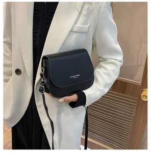 Detail showing fashion trend text print on black leather saddle bag for women