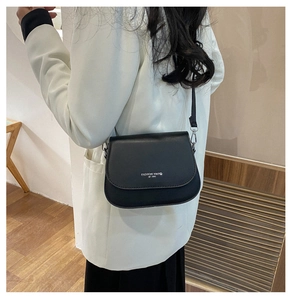 Vue arrière d'un mannequin portant le sac selle en similicuir noir avec texte argenté