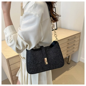 Détail du sac sous le bras à paillettes noires avec fermoir doré et bandoulière