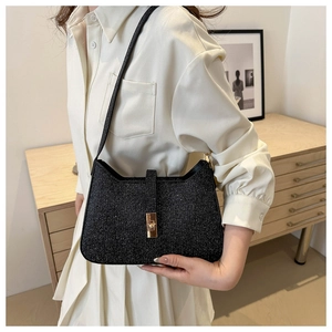 Sac croissant noir scintillant avec boucle dorée porté à l'épaule par un mannequin
