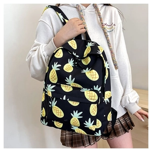 Detail of cute yellow pineapple print on a black large-capacity canvas backpack for girls