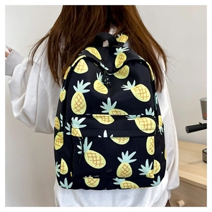 Detailed back view of a black pineapple print backpack worn in a cozy home setting