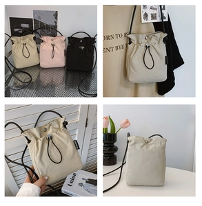 Detail of drawstring nylon crossbody bag with fashion label and adjustable strap