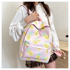 Close-up of pink backpack featuring cute pineapple patterns and front zipper pocket