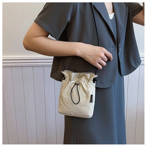 Detail of beige nylon mini crossbody phone bag with drawstring and fashion label