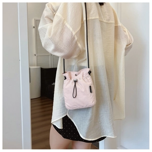 Close-up of pink crossbody phone bag featuring adjustable drawstring and fashion label