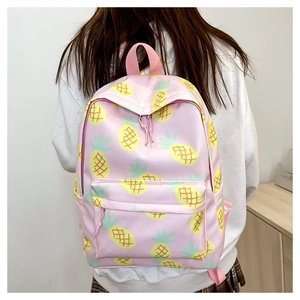 Detailed view of pink backpack with yellow pineapple pattern on a female model
