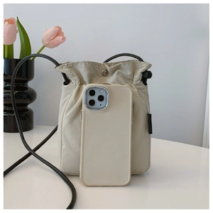 Compact cream nylon drawstring bag shown next to a smartphone for size comparison
