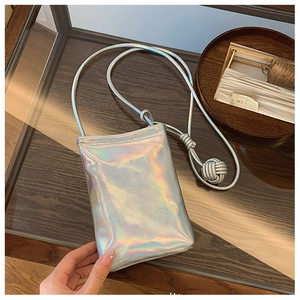 Detail of laser silver crossbody phone bag with woven rope strap and spherical knot decoration