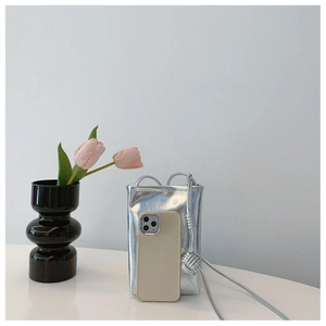 Silver metallic mini shoulder bag with phone size comparison on clean white background