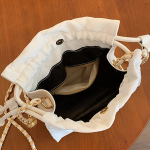 Sac seau matelassé blanc avec bandoulière chaîne dorée et pendentif sphérique