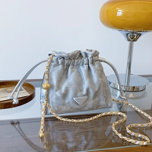 Sac seau matelassé argenté avec bandoulière chaîne dorée et fermeture à cordon