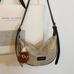 Chic dumpling-shaped crossbody bag with gold glitter finish and plush charm detail