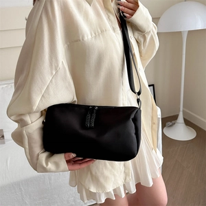 Minimalist black crossbody bag for women with wide adjustable strap and zipper details